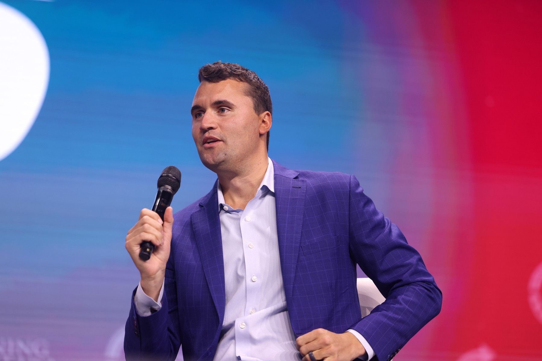 Charlie Kirk holding a microphone at the 2025 Student Action Summit in Tampa, Florida